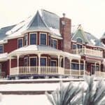 Beautiful snow-covered victorian home with custom wood spindles from Island Post Cap.
